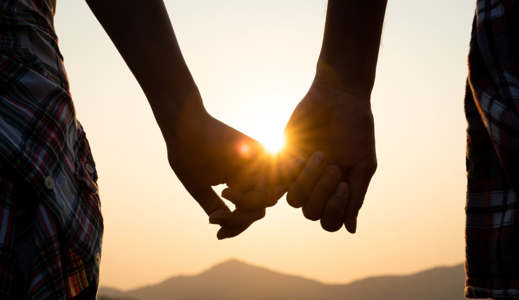 Love and Valentine day concept. A couple holding hand during sunset, a symbol of love and happy relationship.